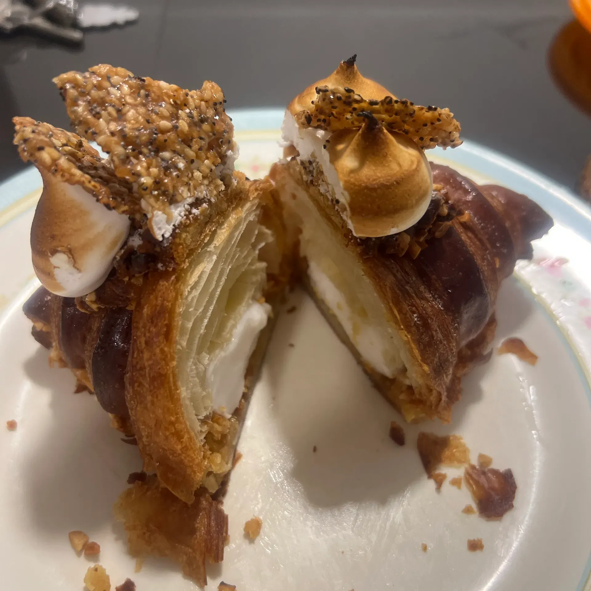 Croissant berinti krim putih dengan meringue bakar, bijan dan biji poppy